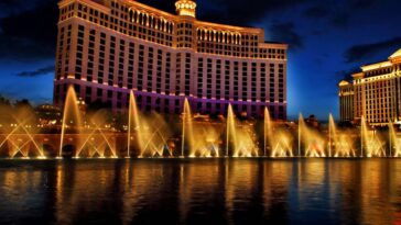 The Fountains of Bellagio in Las Vegas shoot out water at night, while the resort stands tall behind it.