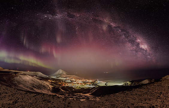 northern lights: A panoramic view of McMurdo Station in the middle of winter with the Aurora Australis, the Milky Way, and the streaks of satellites in the night sky. In the distance are the lights of Pegasus White Ice Runway. June, 2016. Joshua Swanson, NSF, photographer. United States Antarctic Program Photo Library, National Science Foundation.